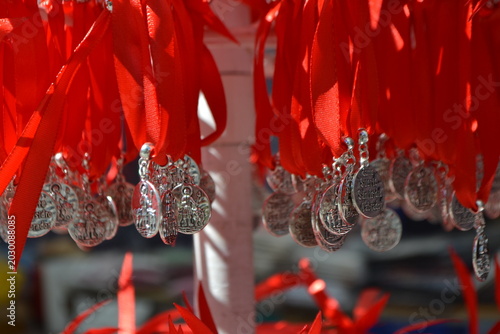 Φωτογραφία Silver religious medals on red ribbon hung in rows at san isidro fair stall for