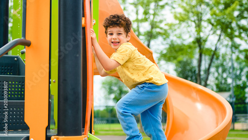 Happy kid slide on playground on summer season