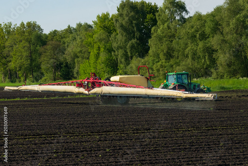 Tractor spraying pesticide on a crop