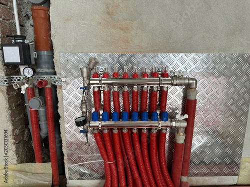 Canvastavla Underfloor heating system. Manifold with pipes in building