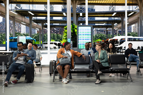 Photography Modern bus terminal with people sitting in waiting area before departure