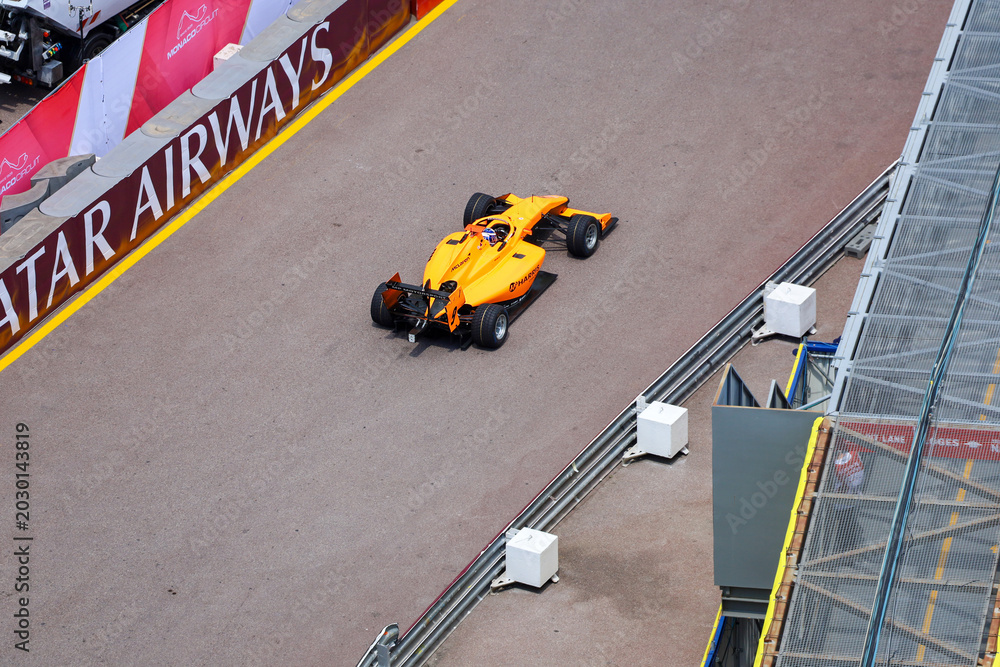 Fototapeta premium Monte Carlo, Monaco on May 23, 2024. High-Angle Shot of Harris Group Orange Formula Racing Car on the Monaco Circuit.