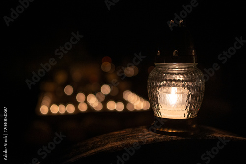 Fotografija Soft light shines from a glass lantern on a dark night during a gathering