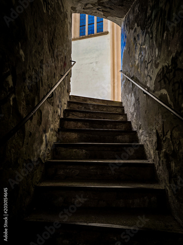 View of a church wall and window from a dark historic passageway in Boskovice