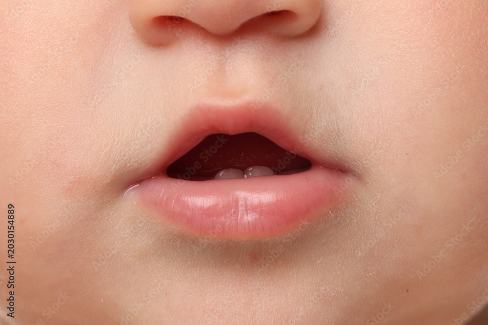 Fototapeta premium Cute child with first baby teeth, closeup