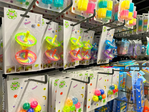 Photos Colorful cheap plastic toys arranged on shelves in a retail supermarket store, r
