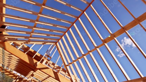 Workers build wooden roof frame with beams trusses as roofing framing