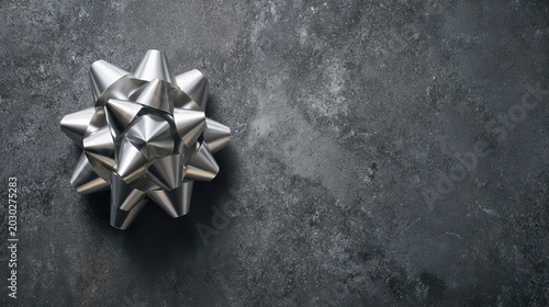 Elegant metallic gift bow on textured gray background, perfect for holiday or celebration decorations and gift wrapping ideas