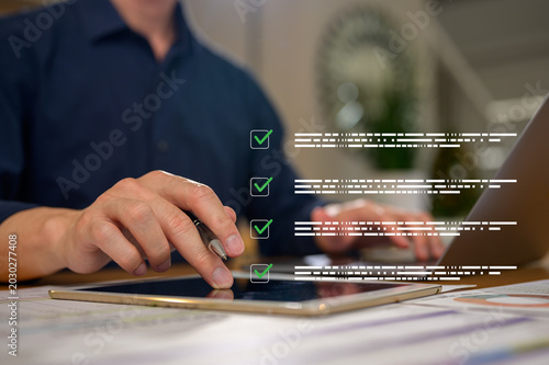 Checklists and Policy and Business Document data system Report workplace safety Concept, Male engineer using tablet and computer laptop checking reports and digital files icon in modern office