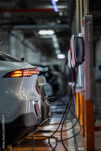 Autonomous EV car charging at AC power station. Self driving vehicle.