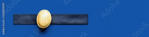 Close Up Shot of Golden Control Dial and Dark Blue Mesh Panel on Textured Blue Background