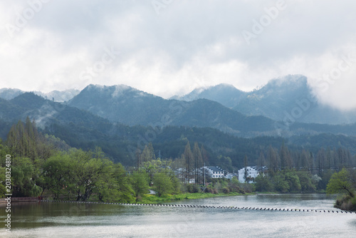 The mountains beside the river are shrouded in mist.