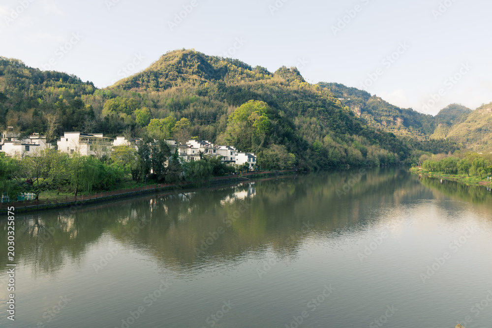 Obraz premium The mountains beside the river are shrouded in mist.