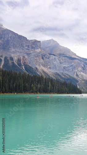 Turquoise glacial lake with pine forest and majestic rocky mountains in western Canada