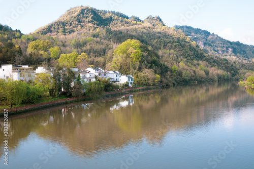The mountains beside the river are shrouded in mist.