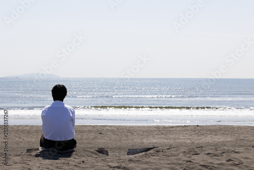 海を眺めている男性の後ろ姿