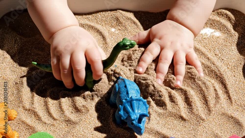 Child's Hands Playing with Dinosaur Toys in Sand. Suitable for Montessori Education, Sensory Play Parenting Guides, Early Childhood Activity Video Content