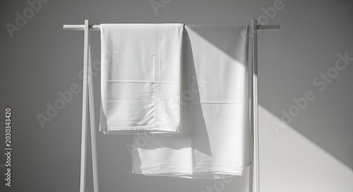 Clean White Bed Sheets Drying on Rack with Natural Sunlight Shadow Play
