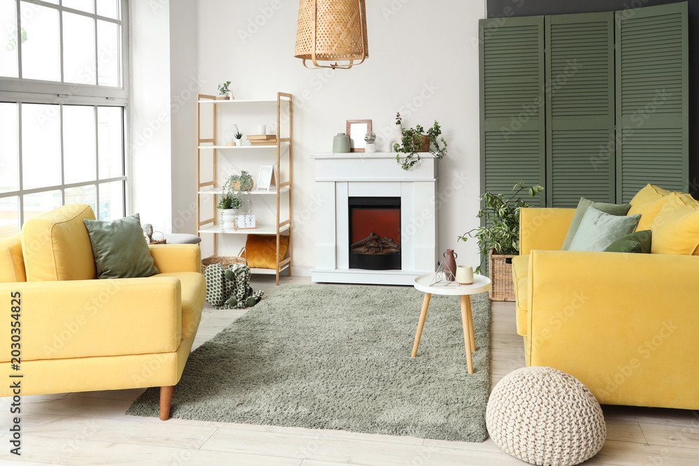 Fototapeta premium Interior of living room with electric fireplace, shelf unit and houseplants