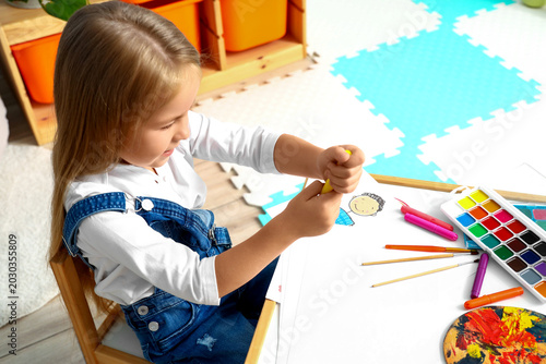 Cute little girl drawing at home