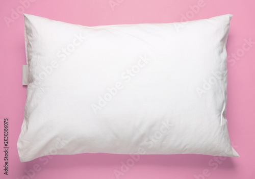White pillow on pink background. Top view