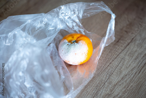 фотографія Moldy mandarin in a plastic bag highlighting spoiled food, improper fruit storage and health risks caused by mold