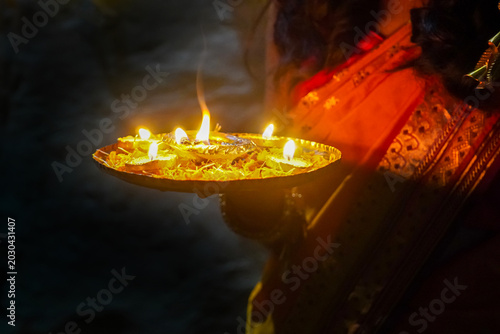 Foto Indian woman holding a tray with Diya oil lamps light, Deepavali or Diwali celebration, Spiritual oil lamp called aarti in India on the occasion of holy ritual at home