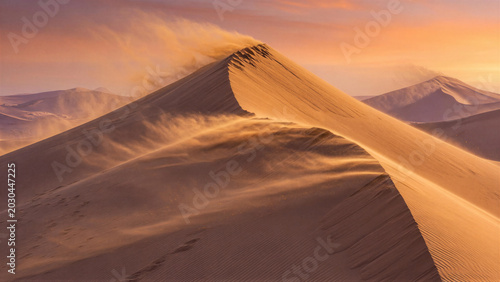 Sand dune shifting under wind in desert sunset landscape
