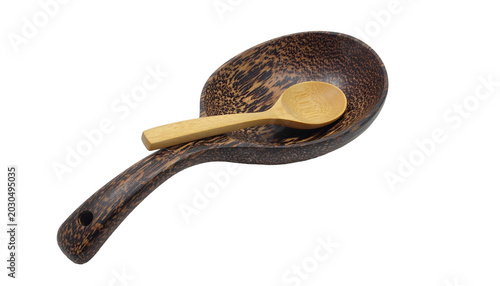 Carved spoon rest holding small spoon, dark wood grain texture