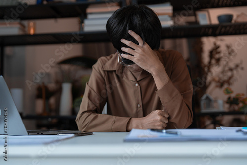 Fotografie Stressed Tired Male Employee Sitting at Desk in Company Office