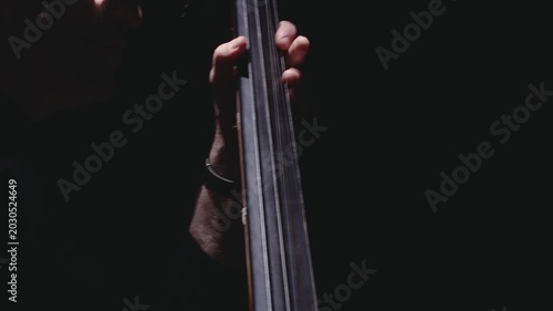 Close-up of hands playing piano keys in dramatic purple light with deep shadows and copy space, capturing music practice, performance, and mood