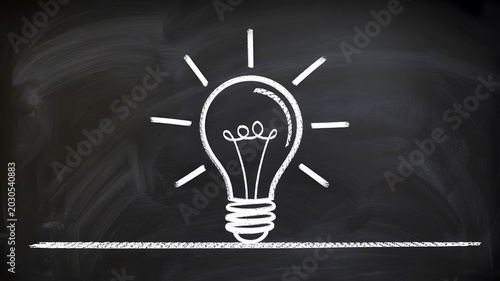 A creative lightbulb idea drawn on a black chalkboard with white chalk