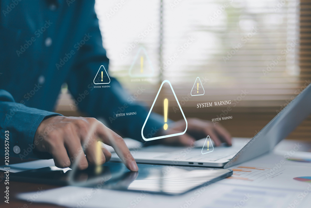 Obraz premium System warning and cybersecurity alert concept with business user using tablet and laptop. Digital risk notification, data breach detection, cyber threat monitoring and online security issue.