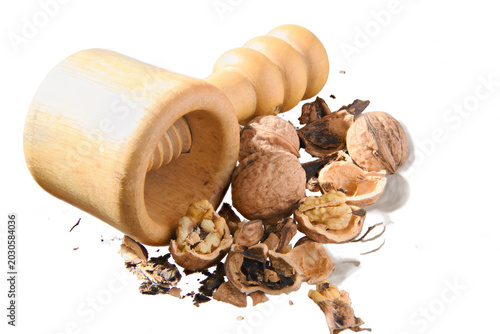 Canvas Print Handheld wooden nutcracker surrounded by cracked walnuts and scattered shells on white background, evoking rustic kitchen prep, natural ingredients and wholesome healthy snacking or baking use