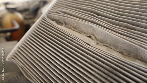 Dirty car air filter.  Close-up of the air filter of an old air conditioning system that has a lot of dust in the groove placed above the engine. Car maintenance concept with focus selection.