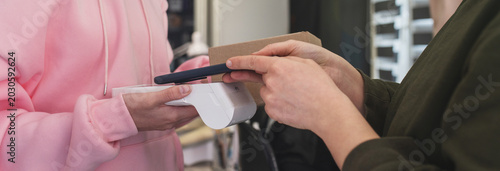 Foto Woman paying with card for parcel delivery for courier