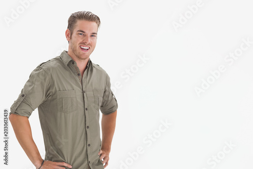 Foto Man posing hands-on-hips, smiling at camera in studio wearing olive shirt, wrist
