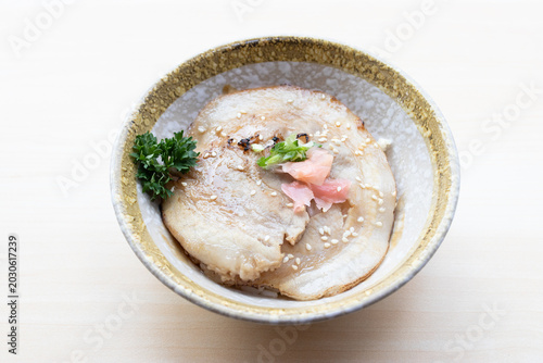 Photos Delicious Japanese Chashu Don featuring a large slice of seared braised pork belly with ginger and sesame seeds over rice in a ceramic bowl