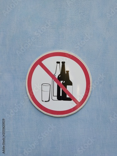 No alcohol sign on blue background: beverage ban concept with bottles and glass