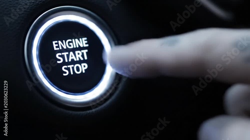 Close Up Shot of a Person Finger Starting a Car Engine Using a Modern Push Button on a Dark Vehicle Dashboard