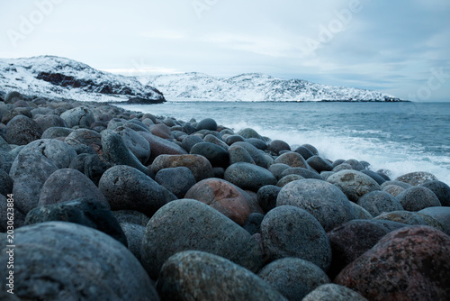 Bild auf Leinwand Rocky beach with round stones in winter Teriberka Arctic ocean coast background
