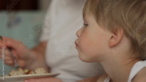 Mother feeding her little boy at home