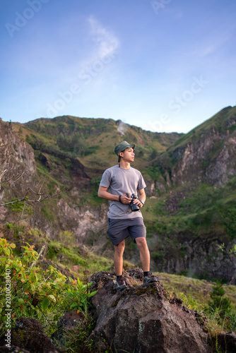 Indonesian man photographer standing near Mount Batur crater in Kintamani Bali