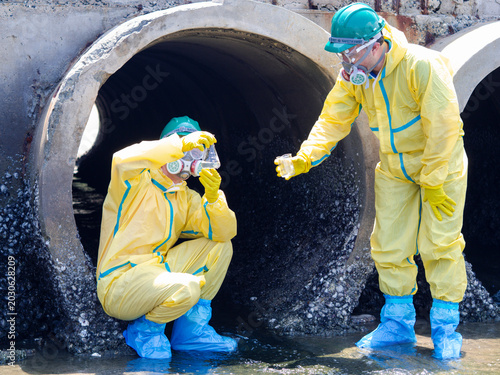 Photos Environmental engineers in chemical protective suits are collecting samples of contaminated water, ecologically and industrially, from nearby areas for testing
