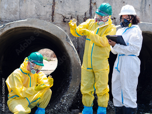 Photos Environmental engineers in chemical protective suits are collecting samples of contaminated water, ecologically and industrially, from nearby areas for testing