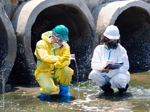 Photos Environmental engineers in chemical protective suits are collecting samples of contaminated water, ecologically and industrially, from nearby areas for testing