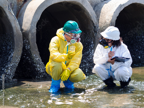 Photos Environmental engineers in chemical protective suits are collecting samples of contaminated water, ecologically and industrially, from nearby areas for testing