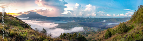 Panoramic sunrise view of Mount Batur caldera, Lake Batur and black lava landscape in Kintamani Bali