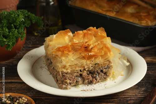 The Kreatopita cake, traditional dish of Greek cuisine, freshly baked on the table	