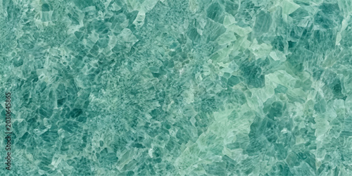 Crushed emerald green crystal pieces create a glittering, textured background, resembling precious gemstones or a vibrant, abstract natural formation.